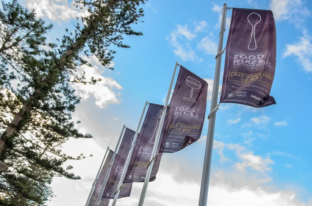 Taste of Manly food and wine festival flags against a blue sky